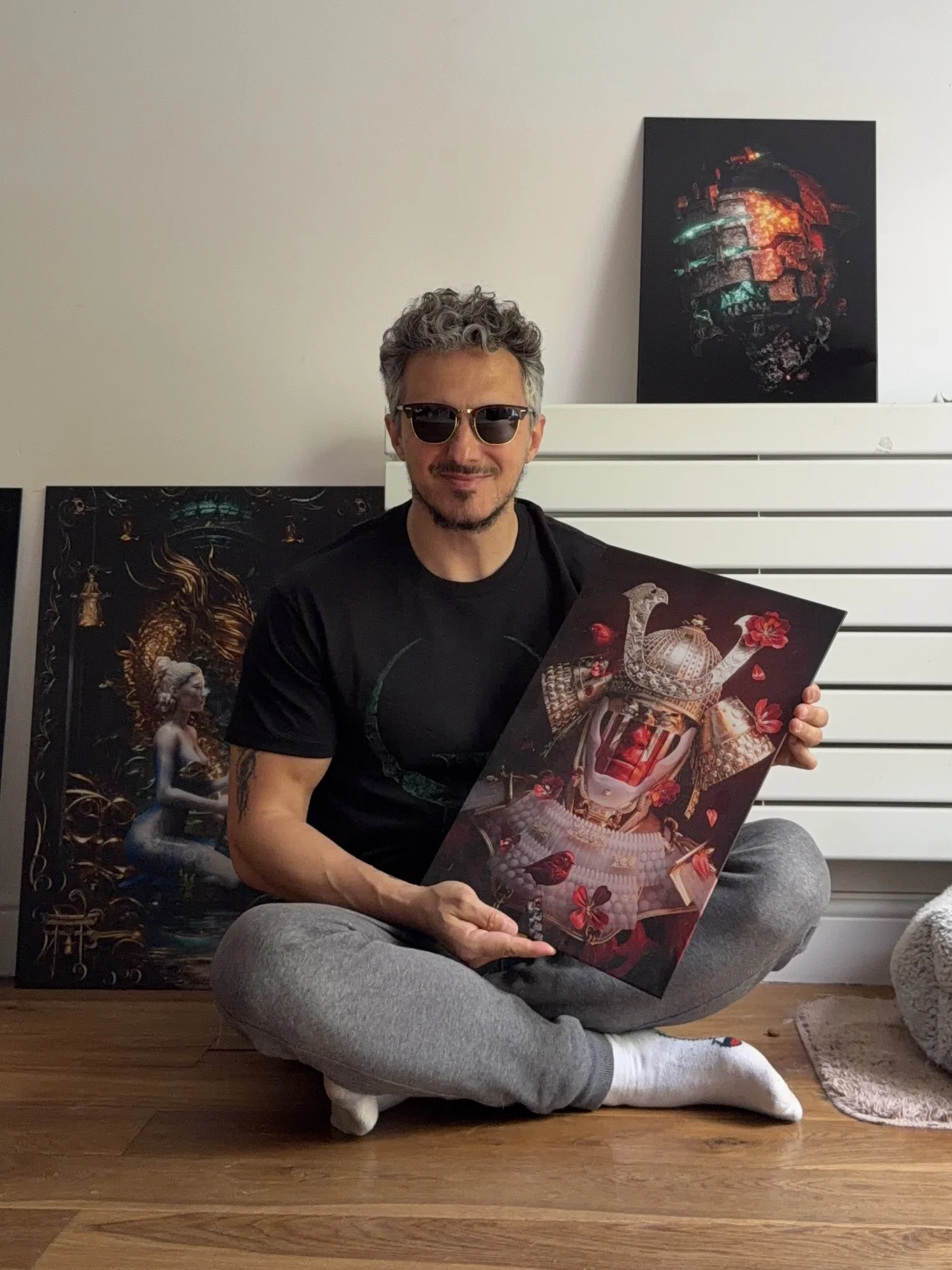 Adam Spizak holding prints of his artwork